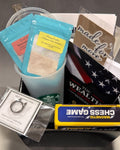 April Financial Readiness ANCHORED Box with The Wealth OP Manual, drink mixes, reusable cup, self-defense ring, magnetic chess game, and sticker